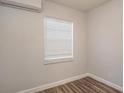 Bright bedroom featuring modern flooring, a window with blinds, and efficient mini-split AC unit at 2926 Fairfield S Ave, St Petersburg, FL 33712