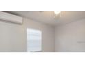 Bright bedroom featuring a ceiling fan, a window with blinds, and efficient mini-split AC unit at 2926 Fairfield S Ave, St Petersburg, FL 33712