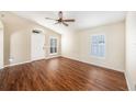 Bright living room with hardwood floors, vaulted ceiling, and large windows with plantation shutters at 3443 Fyfield Court, Land O Lakes, FL 34638