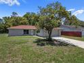 Cozy single-story home featuring a red roof, a well-manicured lawn and an attached two-car garage at 3529 Orion Rd, Spring Hill, FL 34606