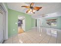 Open-concept living space with tiled floors, ceiling fans, and a view into the kitchen at 3529 Orion Rd, Spring Hill, FL 34606