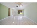 Bright and airy living room featuring tiled flooring, a ceiling fan, and large windows for plenty of natural light at 3529 Orion Rd, Spring Hill, FL 34606