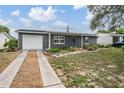 A single-story home featuring a well-manicured front yard and a welcoming front door at 3625 Oakhurst Dr, Holiday, FL 34691