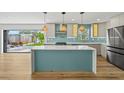 Modern kitchen with island, stylish pendant lighting, stainless steel appliances, and backyard access at 4704 W Fairview Hts, Tampa, FL 33616
