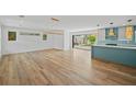 Spacious living room with wood floors flowing into an open layout and direct access to the backyard at 4704 W Fairview Hts, Tampa, FL 33616