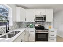 Modern kitchen with white cabinets, stainless steel appliances, and sleek countertops at 6 N Orion Ave, Clearwater, FL 33765