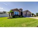 Well-maintained single Gathering home with lush green lawn, stone details, and a convenient two-car garage at 6648 Castle Green Pl, Zephyrhills, FL 33541