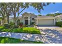 Lovely single-story home featuring well-maintained landscaping, mature trees, and a welcoming two-car garage at 8213 Swann Hollow Dr, Tampa, FL 33647