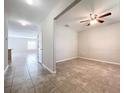Bright living room featuring tile flooring and a ceiling fan for added comfort at 8515 Hunters Fork Loop, Ruskin, FL 33573