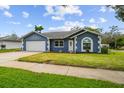 Attractive single-story home boasting a manicured lawn, a blue exterior and a convenient two-car garage at 8823 Aruba Ln, Port Richey, FL 34668