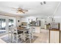 Open-concept kitchen and dining area featuring white cabinetry, stainless steel appliances and tile floors at 901 Strawberry Ln, Brandon, FL 33511