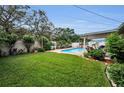 Expansive backyard with a well-maintained lawn, privacy fence, beautiful landscaping, and in-ground pool at 11236 116Th St, Largo, FL 33778