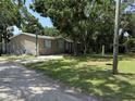 Modest home with lawn and driveway under a shady tree canopy at 12319 Memorial Hwy, Tampa, FL 33635