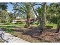 Pleasant view of a well-kept single-story home with a nice lawn and lush landscaping at 13747 Forest Ridge Ct, Hudson, FL 34667