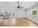 Bright living room with hard surface floors, neutral paint, modern ceiling fan, and open layout at 19267 Wildwood Dr, Brooksville, FL 34601