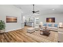 Bright living room boasts luxury vinyl floors, a modern ceiling fan, and opens to the kitchen with stainless appliances at 19267 Wildwood Dr, Brooksville, FL 34601