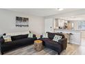 Cozy living area with gray hardwood floors, comfortable seating, and a view of the kitchen at 214 Meadow Ln # 214, Oldsmar, FL 34677