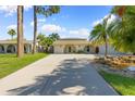 Inviting home featuring a barrel archway, lush tropical landscaping, and a long driveway at 218 N Bay Hills Blvd, Safety Harbor, FL 34695