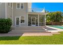 Backyard patio with steps leading to a screened porch and a refreshing private pool at 2803 W Morrison Ave, Tampa, FL 33629