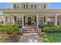 Inviting front porch featuring classic columns, brick steps, and beautiful landscaping at 2803 W Morrison Ave, Tampa, FL 33629