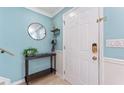 Welcoming foyer with light blue walls, a stylish round mirror, and a convenient console table at 2809 W Platt St # 6, Tampa, FL 33609