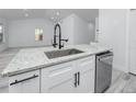 Modern kitchen island featuring a stainless steel sink, granite countertops, and sleek white cabinetry at 2859 38Th N Ave, St Petersburg, FL 33713