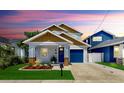 Charming home featuring a colorful front door, landscaped yard, and a one car garage at 2918 N 21St St, Tampa, FL 33605