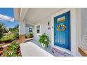 Inviting front porch featuring a vibrant blue door, welcoming wreath, and decorative plant at 2918 N 21St St, Tampa, FL 33605