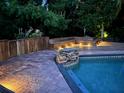 Backyard pool with stone accents, paver deck, wood deck and built in lighting at 3012 Grand View Ave, Clearwater, FL 33759