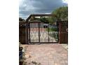 Ornate metal security gate with paved driveway and walkway at 3012 Grand View Ave, Clearwater, FL 33759