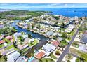 Aerial view of a waterfront community with homes nestled along canals and bays, offering direct access to the open water at 304 Westwinds Dr, Palm Harbor, FL 34683