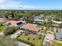 Aerial view of a home featuring a pool, lush landscaping, and a long driveway, surrounded by tropical trees at 309 Palmetto Ln, Largo, FL 33770
