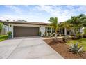 Inviting home showcasing lush landscaping, a well-maintained lawn, and a 2-car garage at 309 Palmetto Ln, Largo, FL 33770