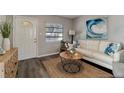 Cozy living room featuring a stylish white sofa, beachy decor, and modern lighting at 3111 W Douglas St, Tampa, FL 33607