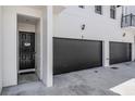 Modern townhome featuring attached garage, a black front door, and exterior lighting at 3210 W Horatio St # 9, Tampa, FL 33609
