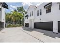 Exterior view of townhome features a gray garage door and mature landscaping at 3210 W Horatio St # 9, Tampa, FL 33609