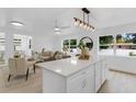 Open-concept kitchen and living area with modern lighting and stainless appliances at 3381 19Th Sw Pl, Largo, FL 33774