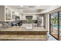 Bright kitchen boasts granite countertops, stainless steel appliances, and a view of the pool at 37147 Foxrun Pl, Zephyrhills, FL 33542
