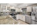 Updated kitchen featuring granite countertops, stainless steel appliances, and stylish backsplash at 37147 Foxrun Pl, Zephyrhills, FL 33542