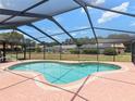 Inviting screened-in pool area perfect for outdoor relaxation and entertainment under sunny blue skies at 37147 Foxrun Pl, Zephyrhills, FL 33542