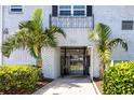 Community entrance with secured gate, mature landscaping and beautiful white brick facade at 4050 4Th N St # 116, St Petersburg, FL 33703