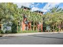 Exterior of a multi-story building featuring red and green hues, surrounded by palm trees and lush greenery at 410 S Armenia Ave # 926, Tampa, FL 33609