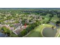Scenic aerial view of golf course community with lush greenery, lake, and well-maintained townhome complex at 4213 Arborwood Ln, Tampa, FL 33618