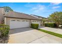 Attractive townhome featuring a one-car garage, driveway, and manicured landscaping at 4213 Arborwood Ln, Tampa, FL 33618