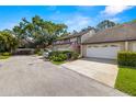 Charming townhome exterior featuring a two-car garage, well-manicured landscaping, and a welcoming facade at 4213 Arborwood Ln, Tampa, FL 33618