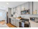 Bright kitchen features stainless steel appliances, modern cabinetry, and a stylish backsplash at 4521 S Cooper Pl, Tampa, FL 33611