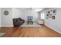 Comfortable living room featuring hardwood floors, a plush couch, and a ceiling fan at 4521 S Cooper Pl, Tampa, FL 33611