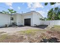 Detached white garage with black garage door and adjacent fenced yard space at 521 51St S Ave, St Petersburg, FL 33705