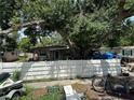 A home nestled under a grand tree, framed by a white picket fence at 6817 S Wall St, Tampa, FL 33616