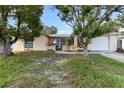 Charming single-story home featuring a front lawn and an attached two-car garage at 7040 Fox Hollow Dr, Port Richey, FL 34668